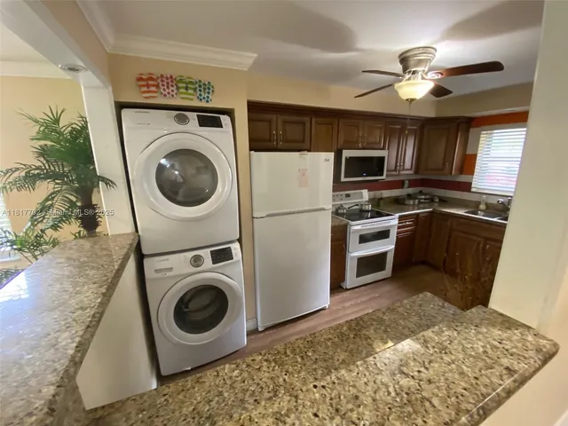 a kitchen with kitchen island a stove a washer and dryer