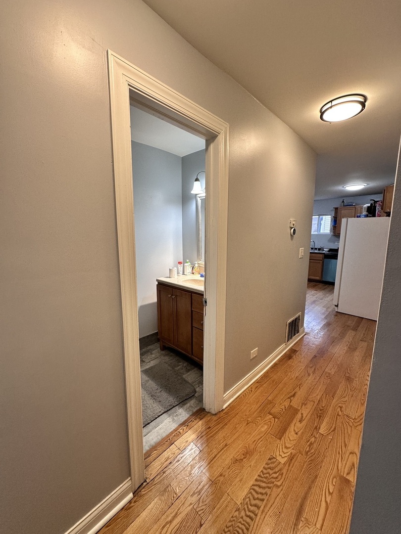 263 Blackberry Drive Bolingbrook, IL 60440 - Photo 9 of 50 a view of a hallway and a kitchen with wooden floor