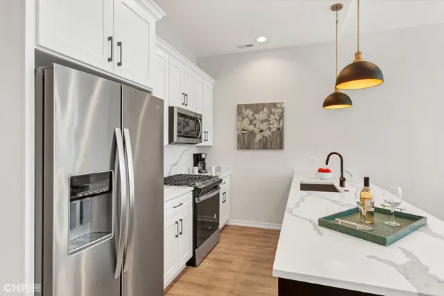 a kitchen with stainless steel appliances granite countertop a refrigerator sink and stove
