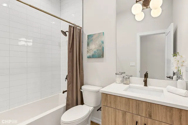 a bathroom with a sink a toilet a mirror and shower