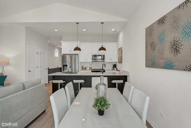 a open dining room with stainless steel appliances kitchen island a table and chairs