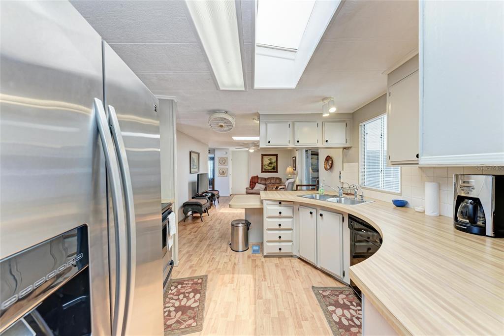 5619 Bayshore Road, Unit 164 Palmetto, FL 34221 - Photo 12 of 42 a kitchen with stainless steel appliances granite countertop a sink refrigerator stove and wooden floor