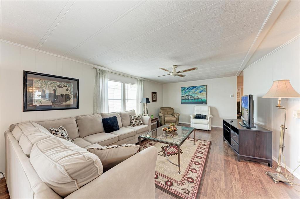 5619 Bayshore Road, Unit 164 Palmetto, FL 34221 - Photo 9 of 42 a living room with furniture wooden floor and a flat screen tv