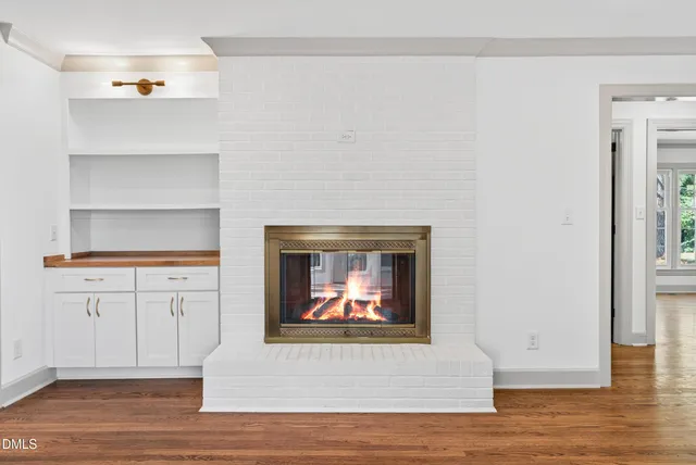a room with kitchen island a sink wooden floor and a chandelier