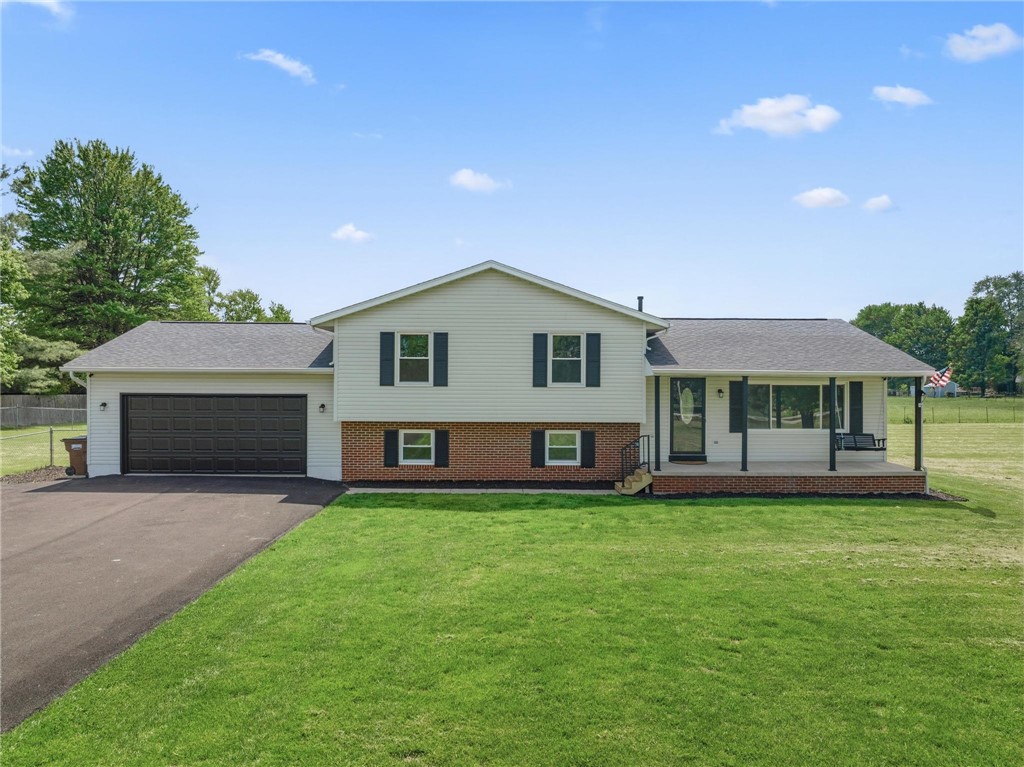 1353 Foust Road Xenia, OH 45385 - Photo 1 of 50 This charming home offers a welcoming facade with a covered front porch and an attached garage.