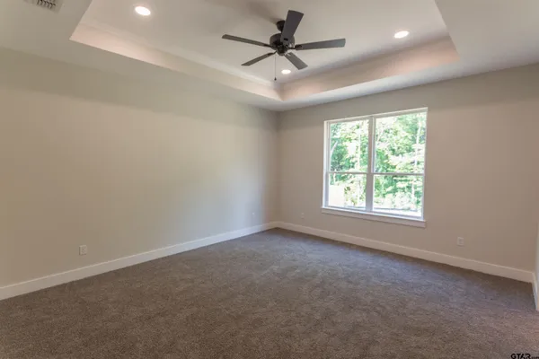 an empty room with a window and a fan