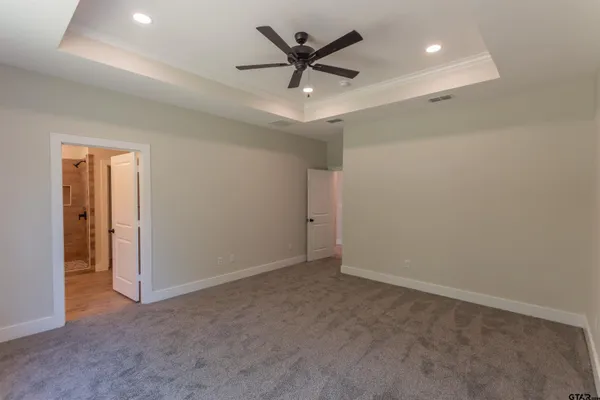 an empty room with closet and a ceiling fan