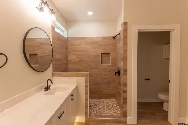 a bathroom with a sink a toilet and a mirror