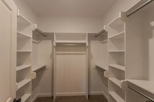 a view of walk in closet with empty racks