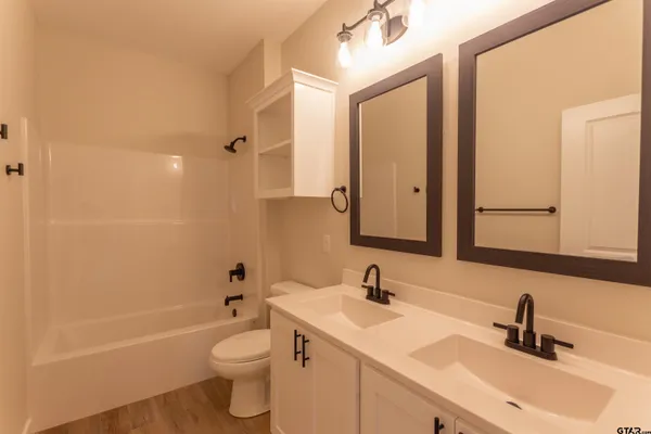 a bathroom with a double vanity sink toilet and shower