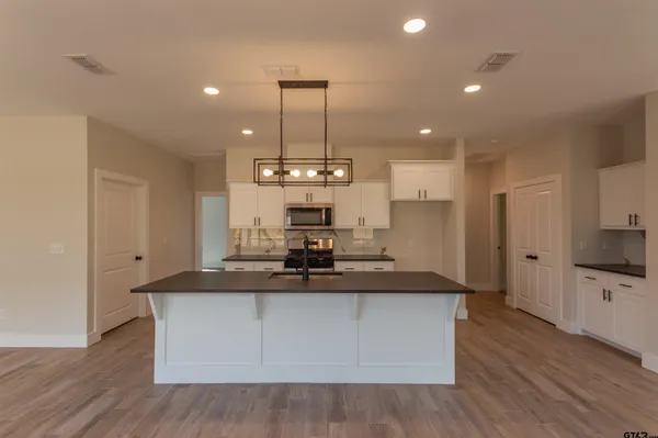 a kitchen with kitchen island stainless steel appliances a sink and a counter top space