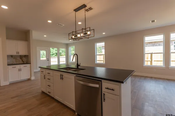 a kitchen with granite countertop a sink cabinets and window