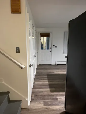 a view of a hallway with wooden floor and staircase