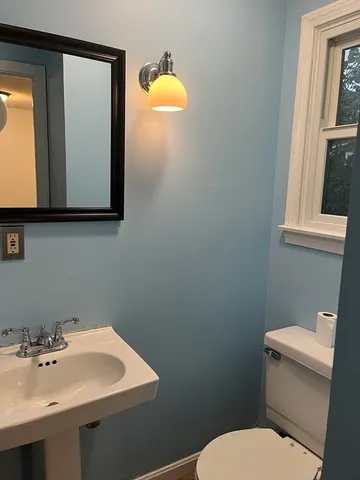 a bathroom with a sink a toilet and mirror