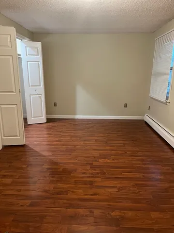 a view of room with window and wooden floor