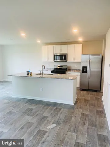a kitchen with stainless steel appliances a refrigerator sink and microwave