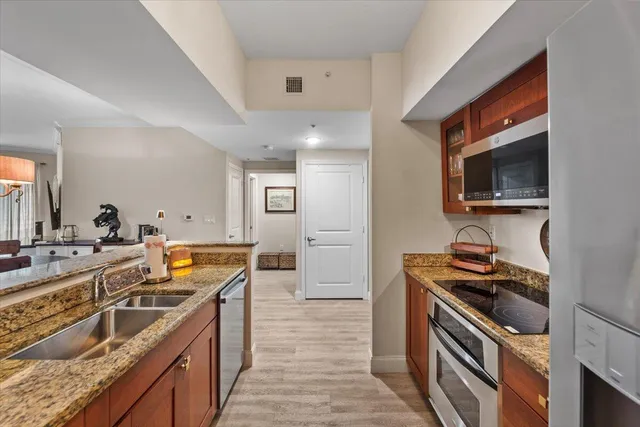 a kitchen with granite countertop a sink and steel appliances