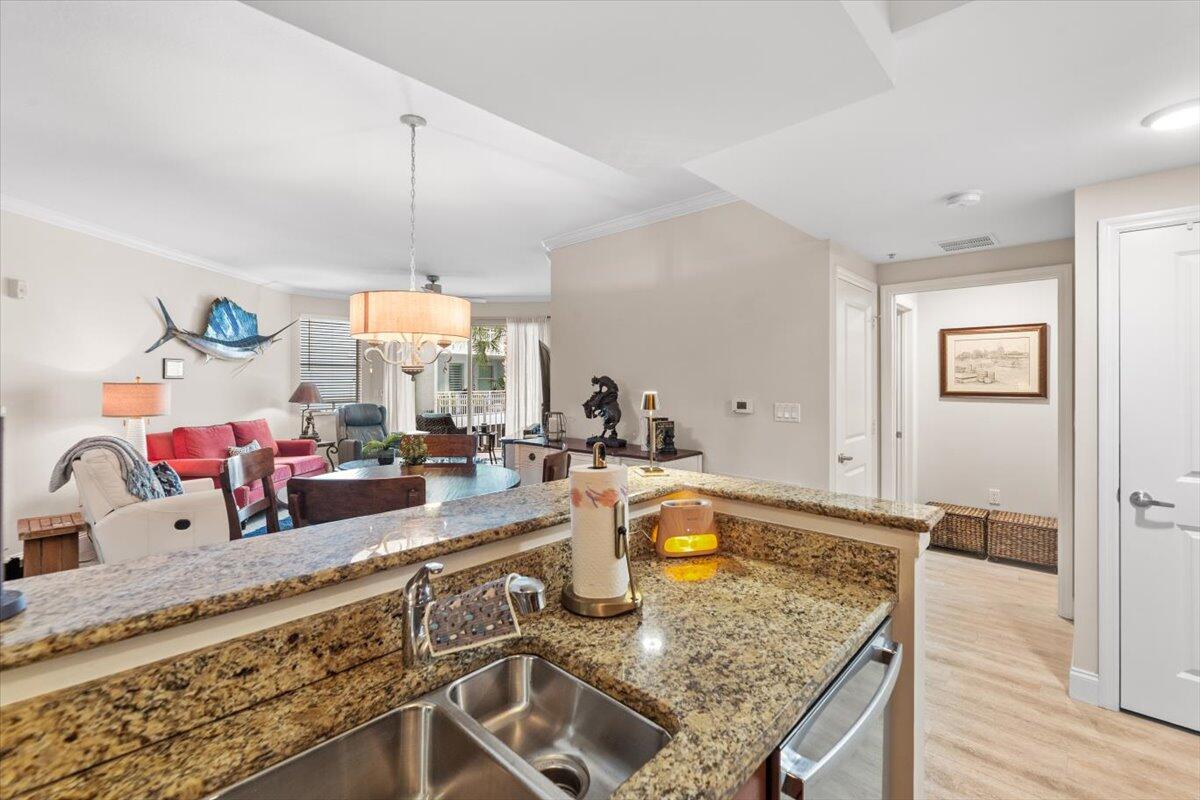 815 Northwest Flagler Avenue, Unit 201 Stuart, FL 34994 - Photo 15 of 43 a kitchen with stainless steel appliances granite countertop a sink counter space and living room view