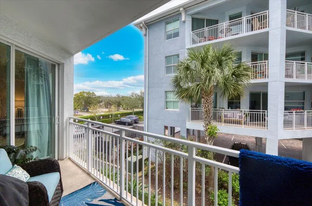 a view of a balcony with couches plants and wooden fence