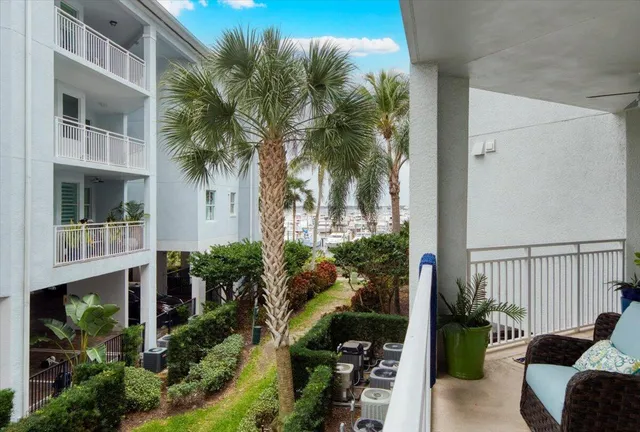 a view of a balcony with potted plants and palm trees