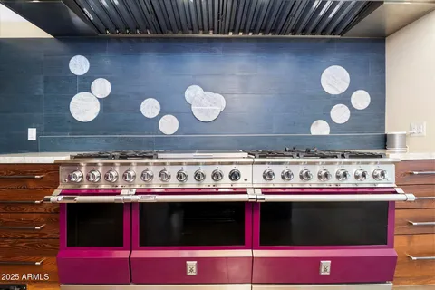a living room with stainless steel appliances furniture a rug and a view of kitchen