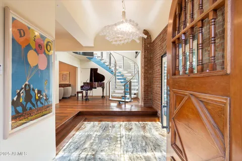 a living room with furniture chandelier and a large window