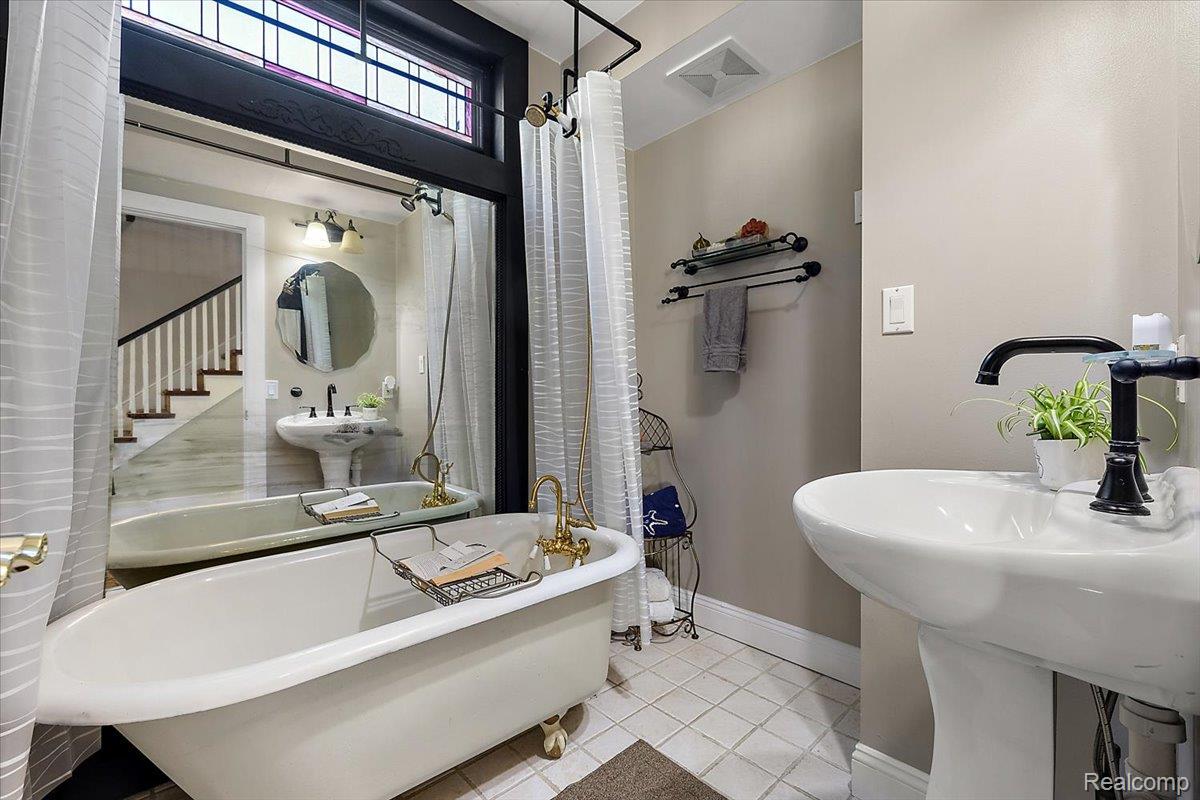 5815 Chicago Road Warren, MI 48092 - Photo 23 of 47 Full bath with a freestanding bath, light tile patterned floors, and a shower with shower curtain