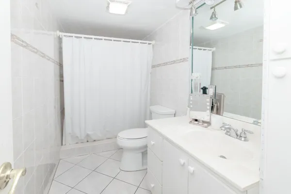 a bathroom with a granite countertop sink a toilet and a mirror