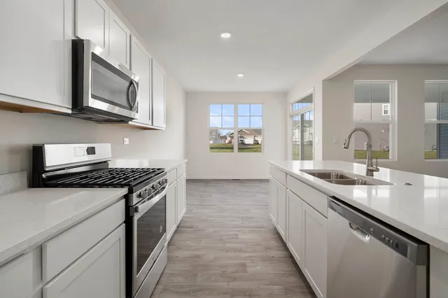 a kitchen with stainless steel appliances granite countertop a sink and stove top oven