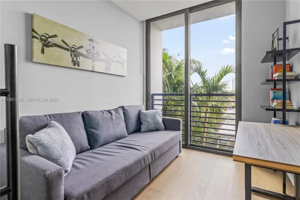 a living room with furniture and a floor to ceiling window