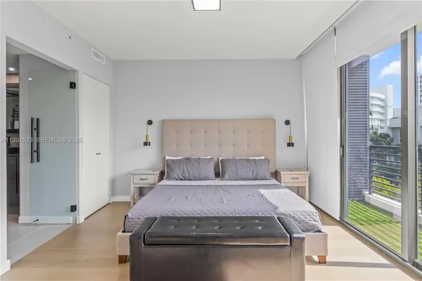 a bedroom with a bed and wooden floor