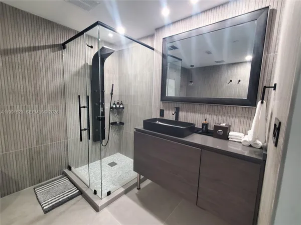 a bathroom with a double vanity sink mirror and shower