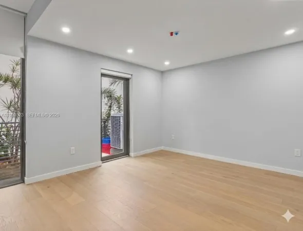 an empty room with entrance and windows