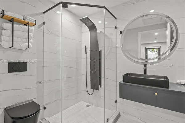 a bathroom with a sink a toilet and shower