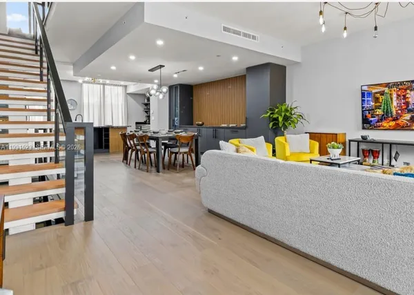 a living room with furniture and kitchen view