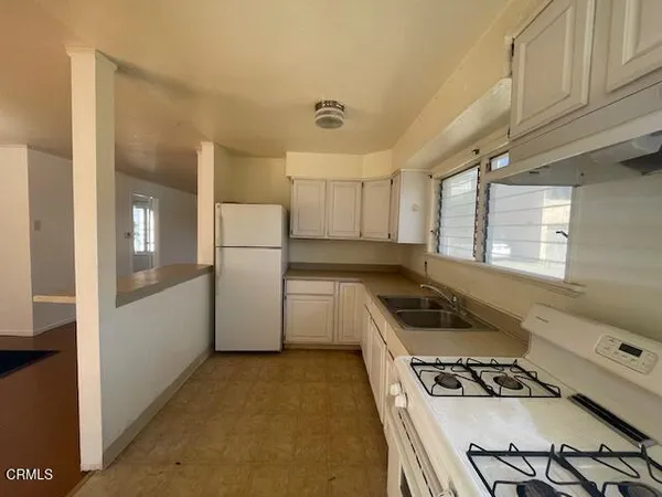 a kitchen with a stove a refrigerator and a more cabinets