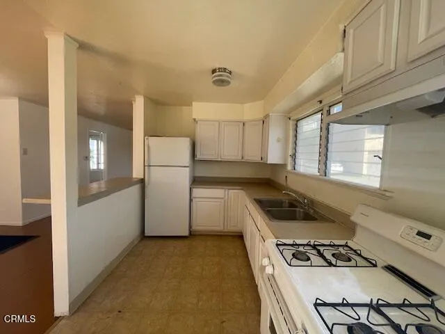 a kitchen with a stove a refrigerator and a more cabinets