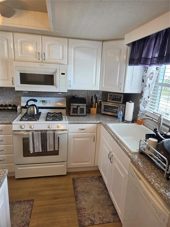 7 Dunoon Place, Unit 309 Dunedin, FL 34698 - Photo 10 of 25 a kitchen with cabinets appliances a sink and a counter space