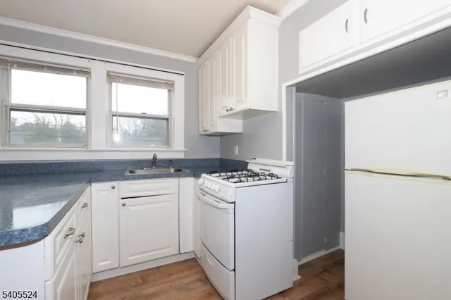 a kitchen with white cabinets and white appliances