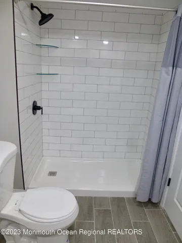 a bathroom with a toilet and a shower