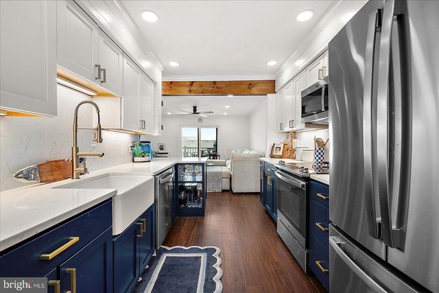 a kitchen with stainless steel appliances a sink cabinets and wooden floor