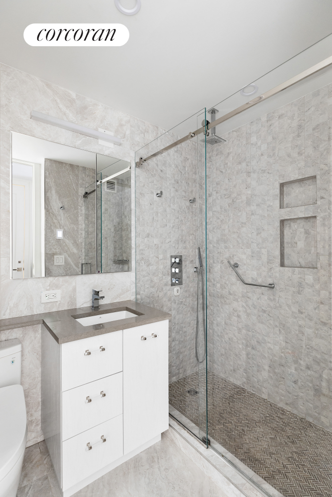 170 East 87th Street, Unit W7C Manhattan, NY 10128 - Photo 13 of 15 a bathroom with a shower sink and mirror