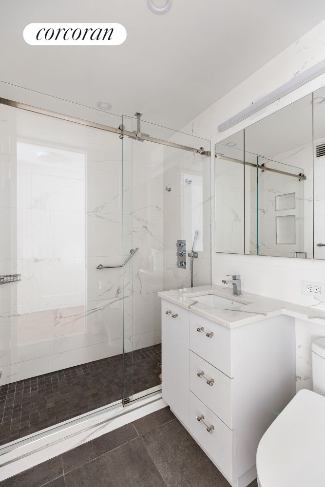 170 East 87th Street, Unit W7C Manhattan, NY 10128 - Photo 14 of 15 a bathroom with a double vanity sink toilet and shower