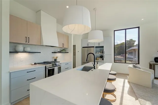 a kitchen with stainless steel appliances a table and chairs in it