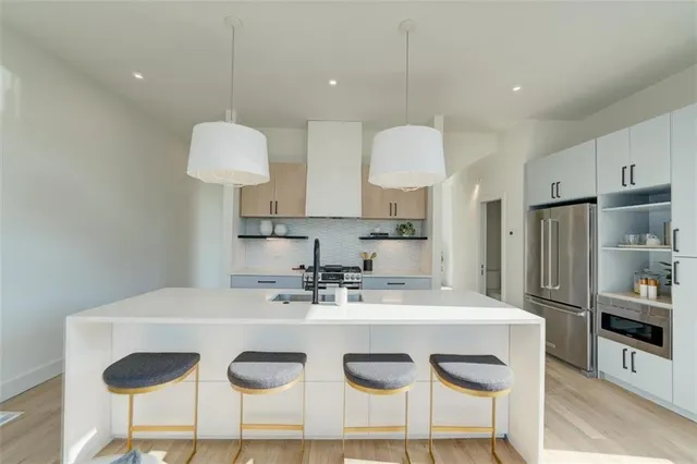 a kitchen with stainless steel appliances granite countertop a sink stove and refrigerator