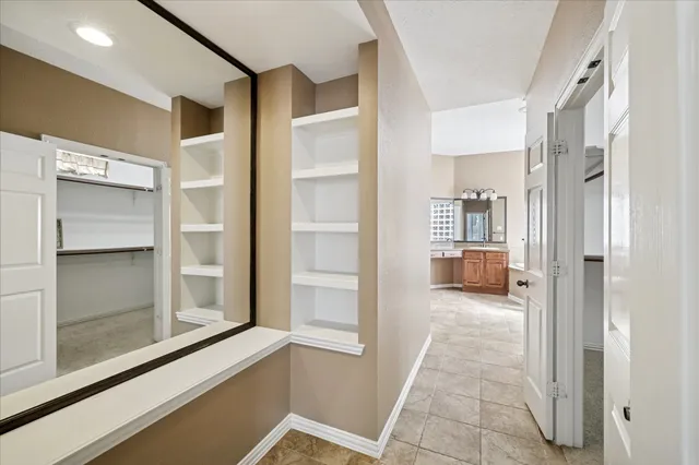 a bathroom with a granite countertop sink and mirror with bathtub