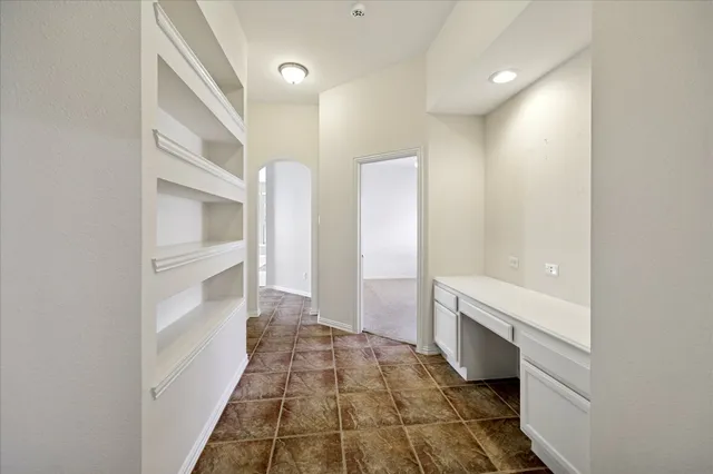 a spacious bedroom with a bed a couch and a chandelier