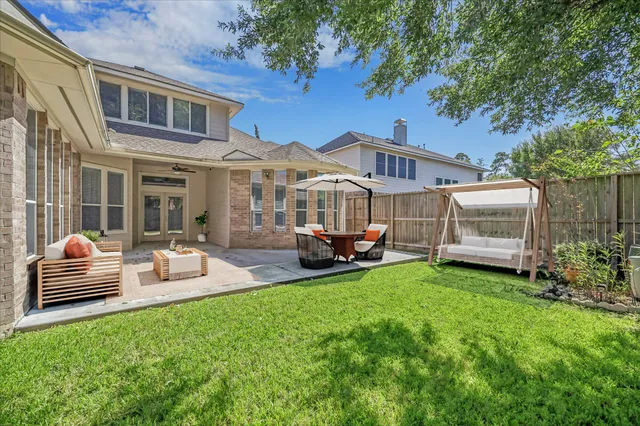 a view of a yard in front of a house with a large tree