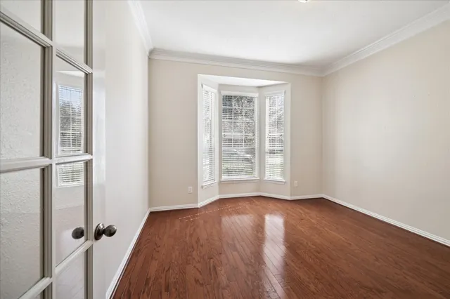 an empty room with wooden floor and a window