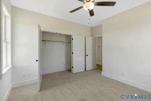 an empty room with a window and a fan